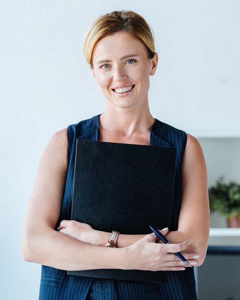 happy adult businesswoman holding folder and pencil near table i